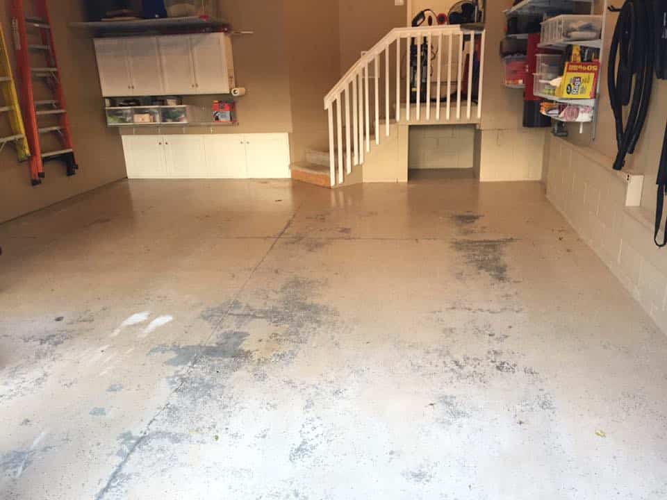 Garage floor before coating, cracked and stained with tire marks