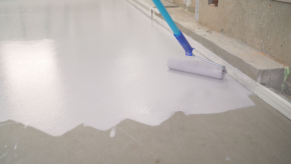 Roller applying a light gray solid color coating