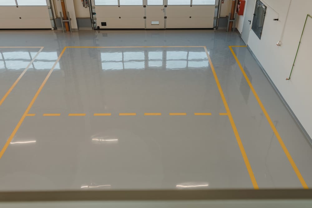 Shop floor with a gray polyurea coating and yellow lane striping