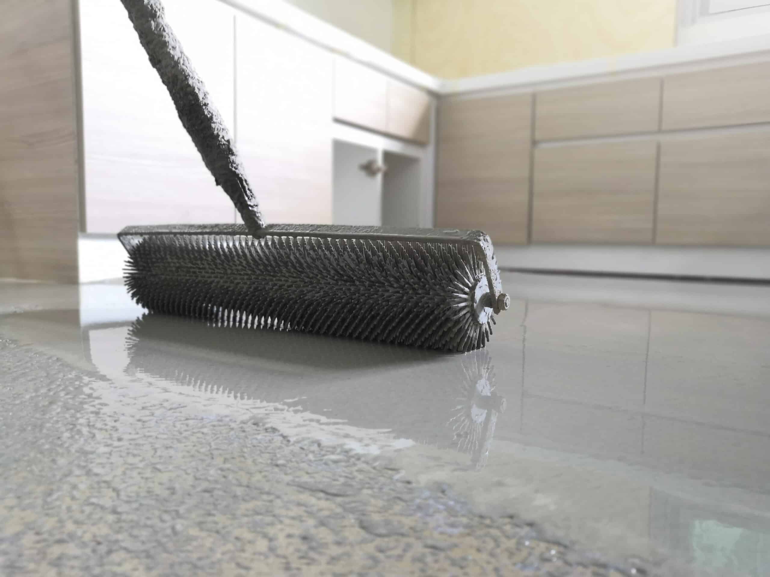 Spiked roller leveling fresh epoxy in a home