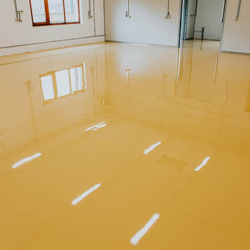 Shiny yellow epoxy floor in empty room