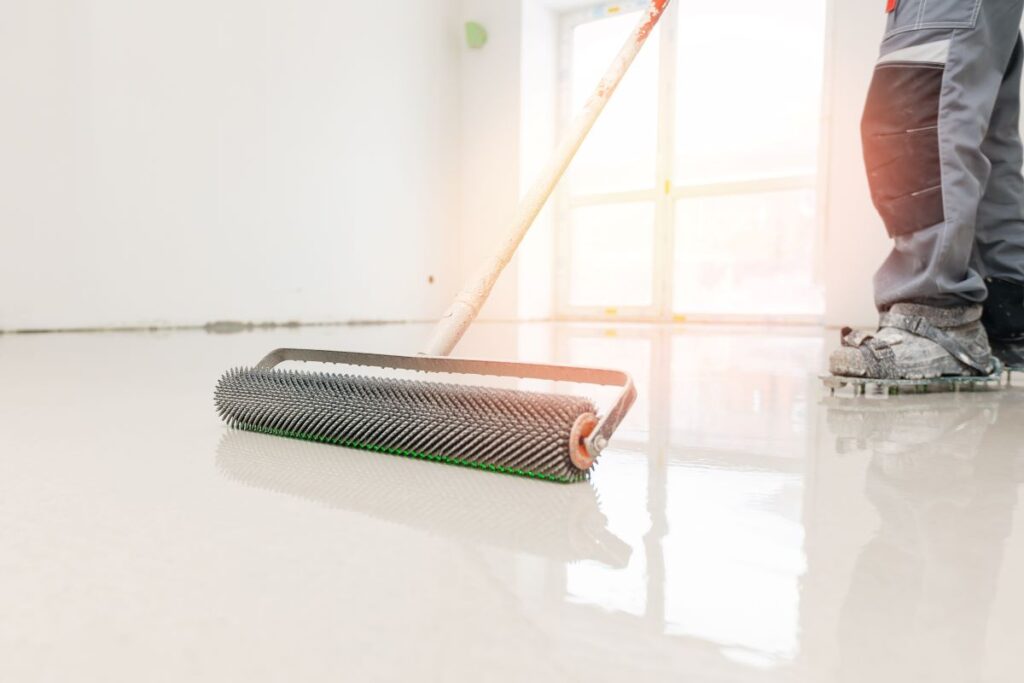 Applying epoxy floor with spiked roller tool