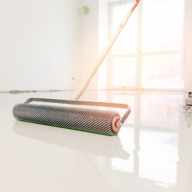 Applying epoxy floor with spiked roller tool