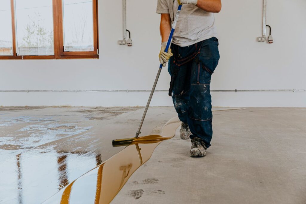 Worker applying epoxy floor coating