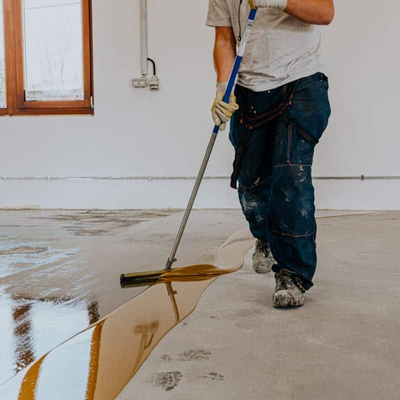 Worker applying epoxy floor coating