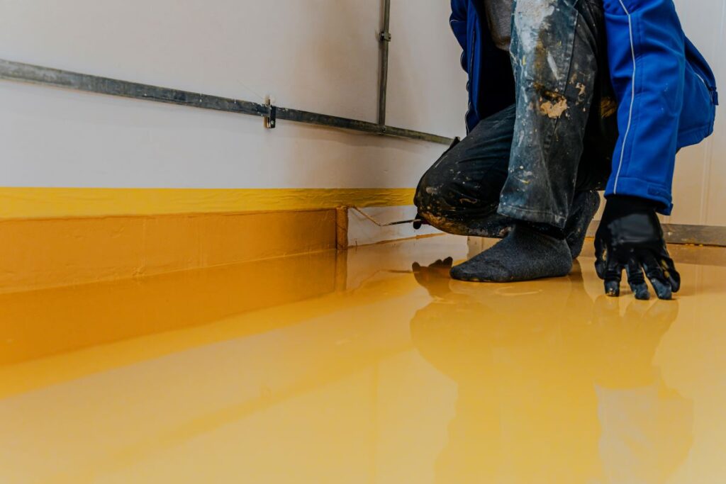 Worker applying polyurea floor coating in Reno, Nevada
