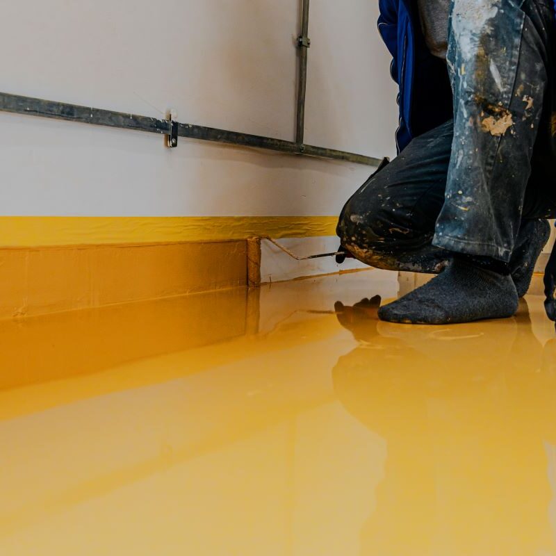 Worker applying polyurea floor coating in Reno, Nevada