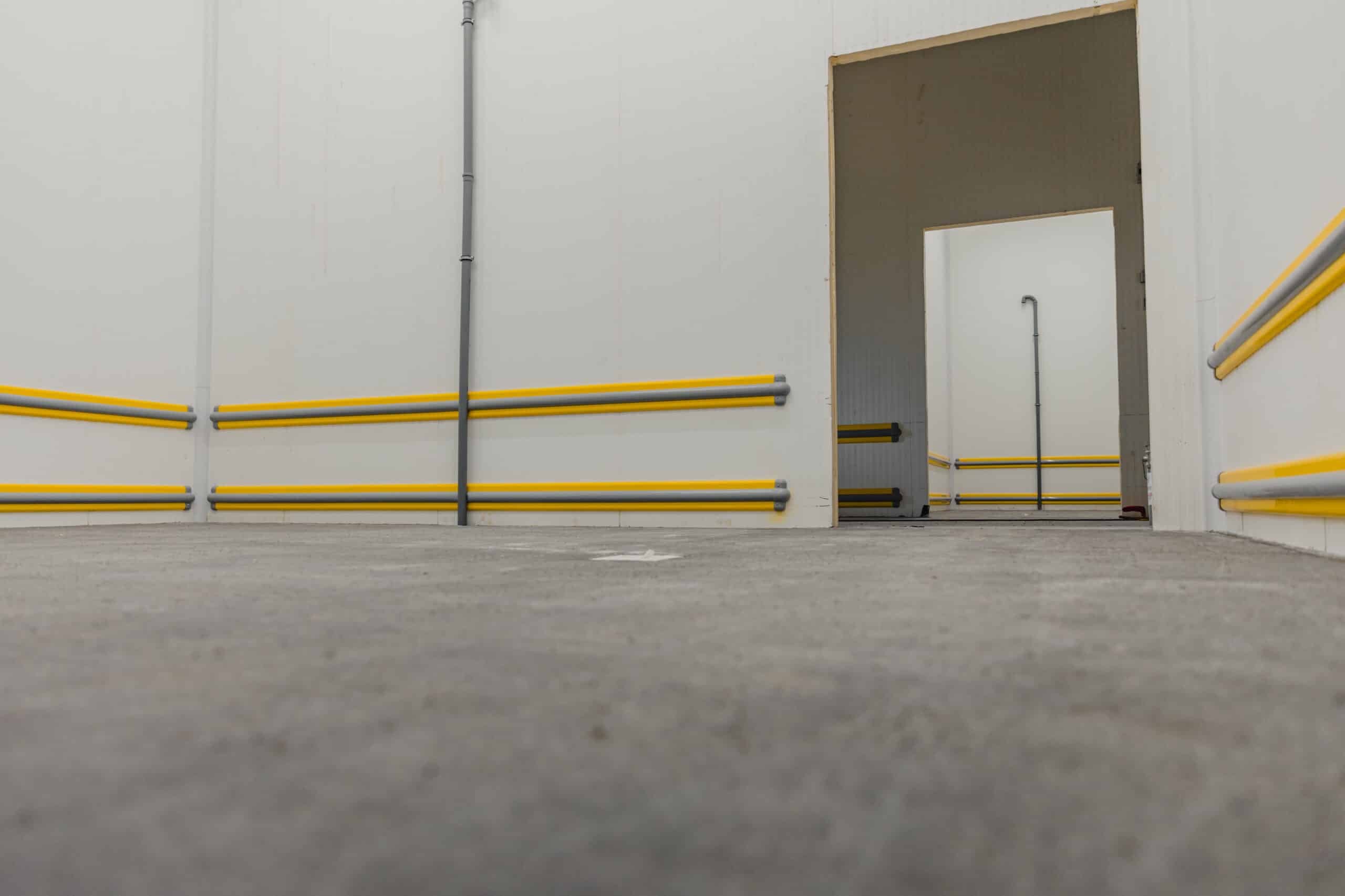 Industrial hallway with yellow railings and pipes
