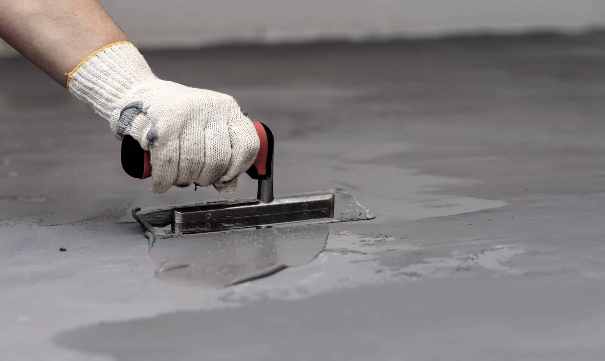 Hand smoothing wet concrete with trowel.