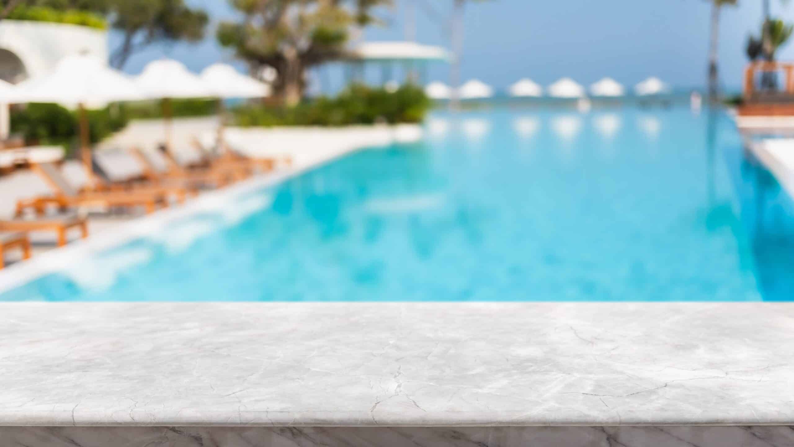 Empty marble table near a luxury swimming pool