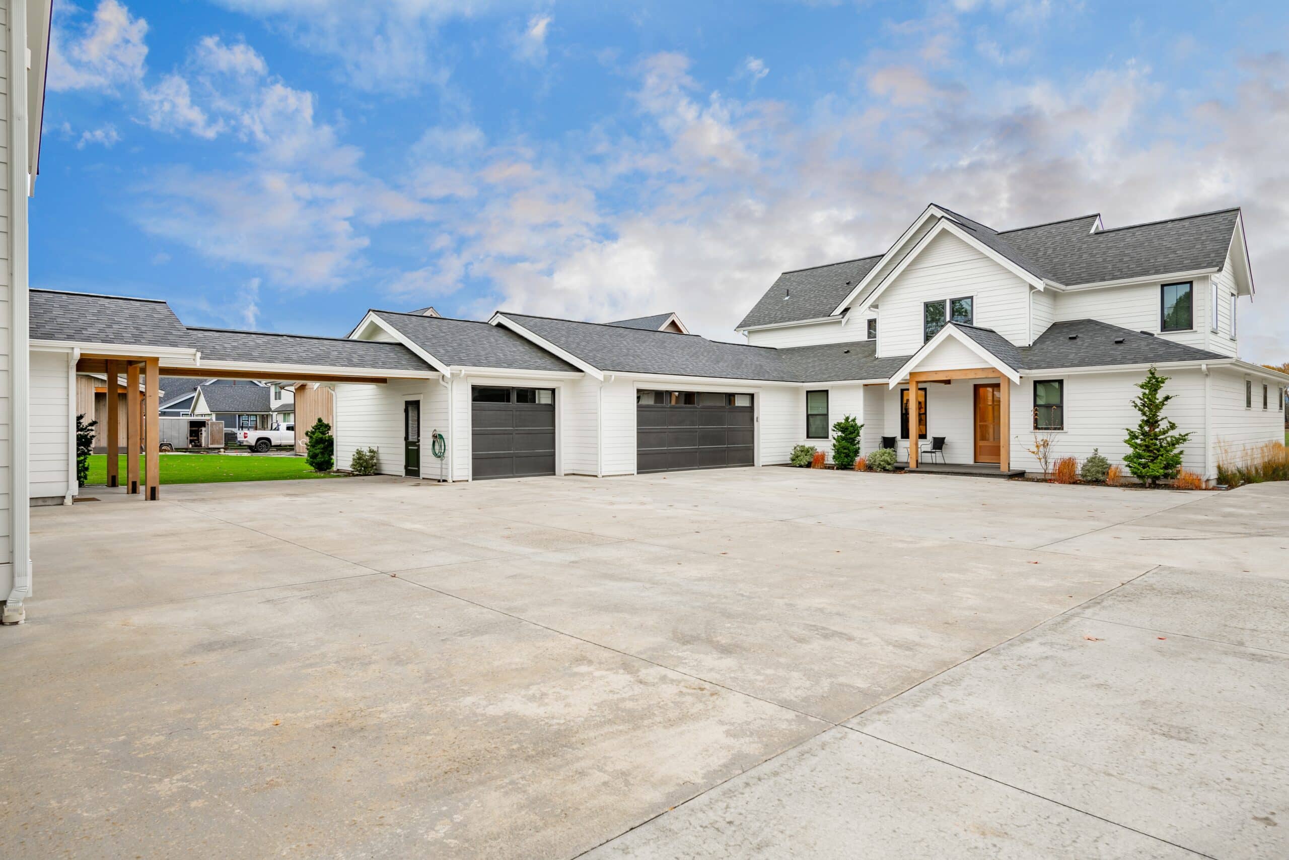 Modern white suburban house with spacious driveway.