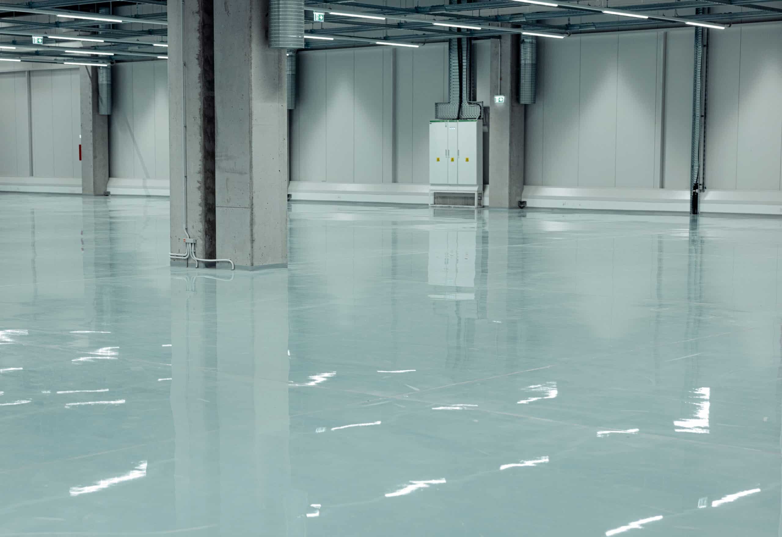 Empty industrial warehouse with polished concrete floor.