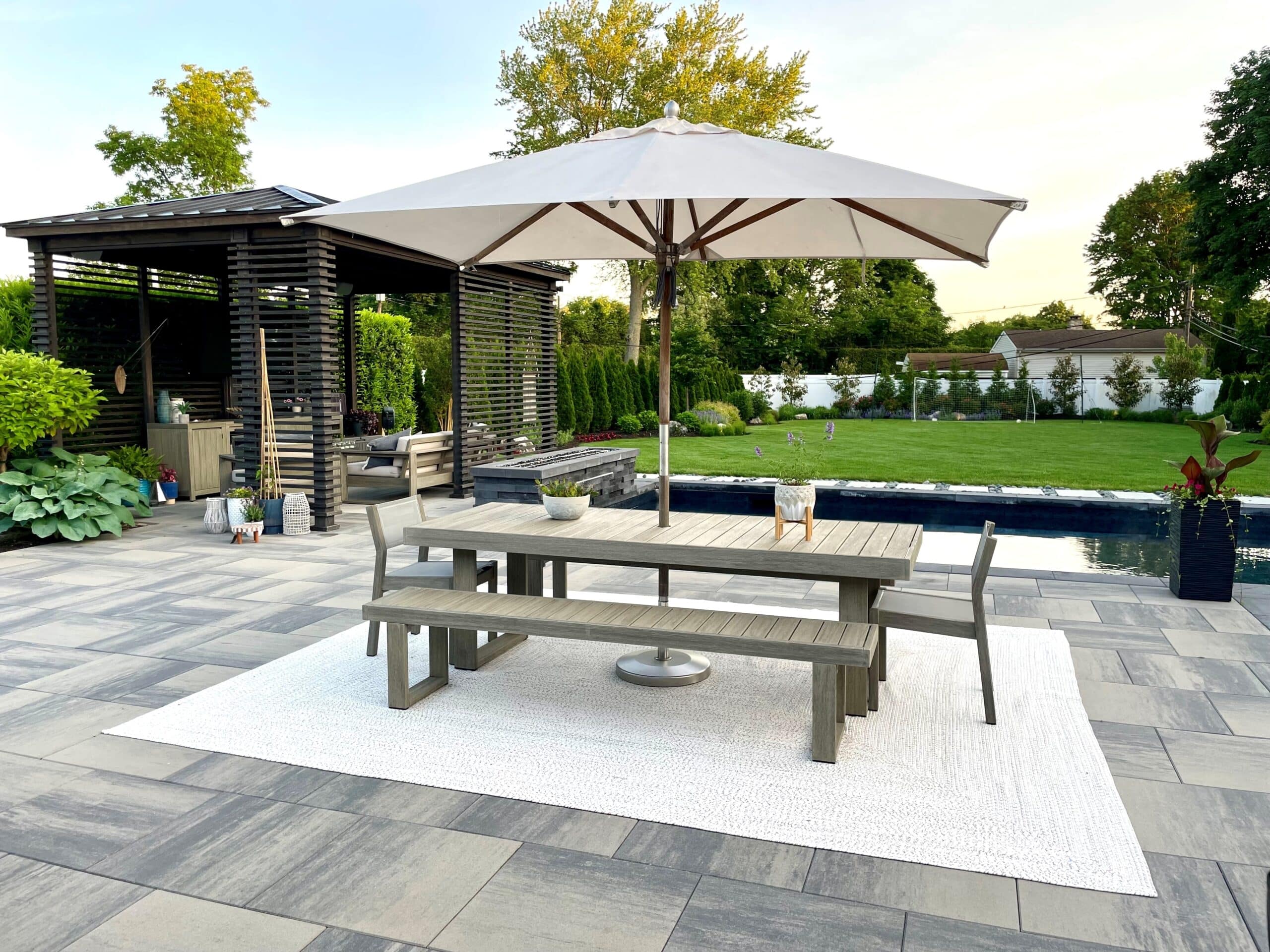 Outdoor patio with table, umbrella, and garden view.