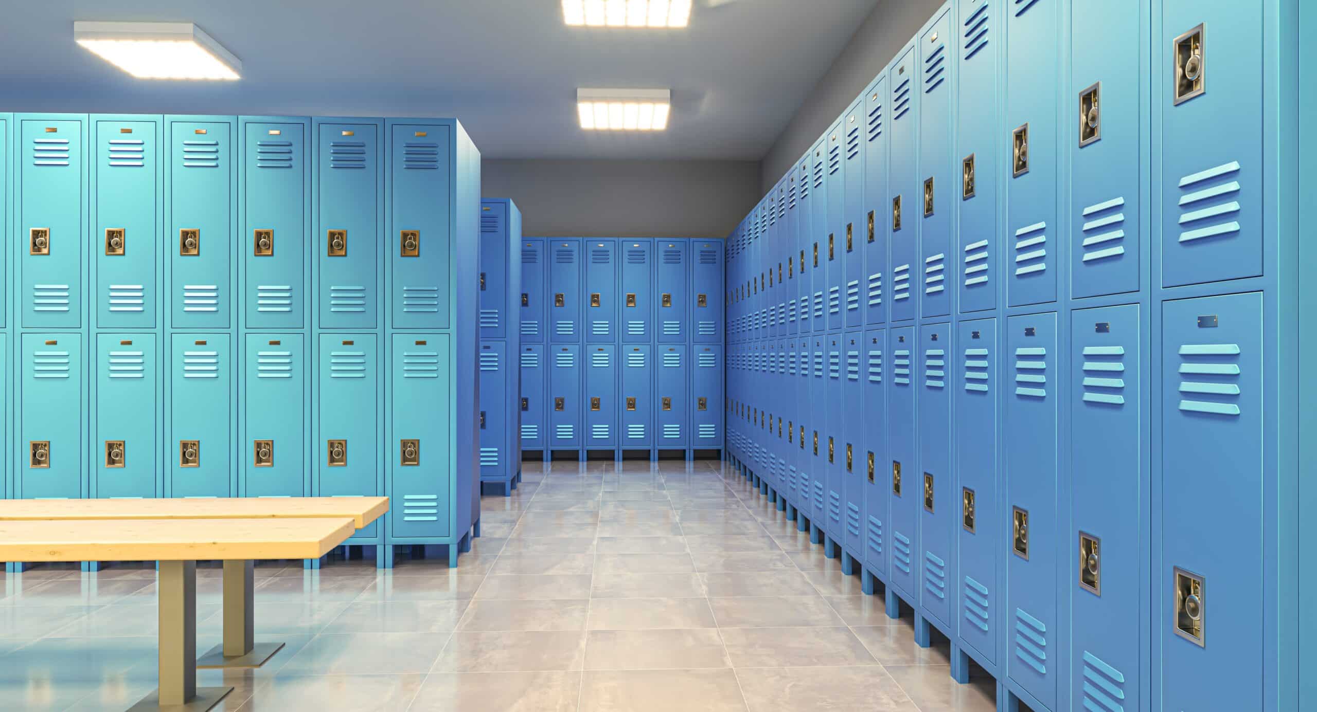 Empty locker room with blue lockers and bench.